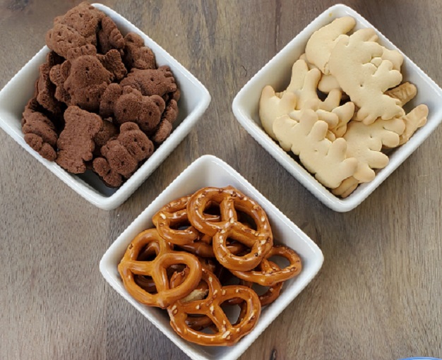 mini cookies, pretzels in white serving dishes for dessert dip