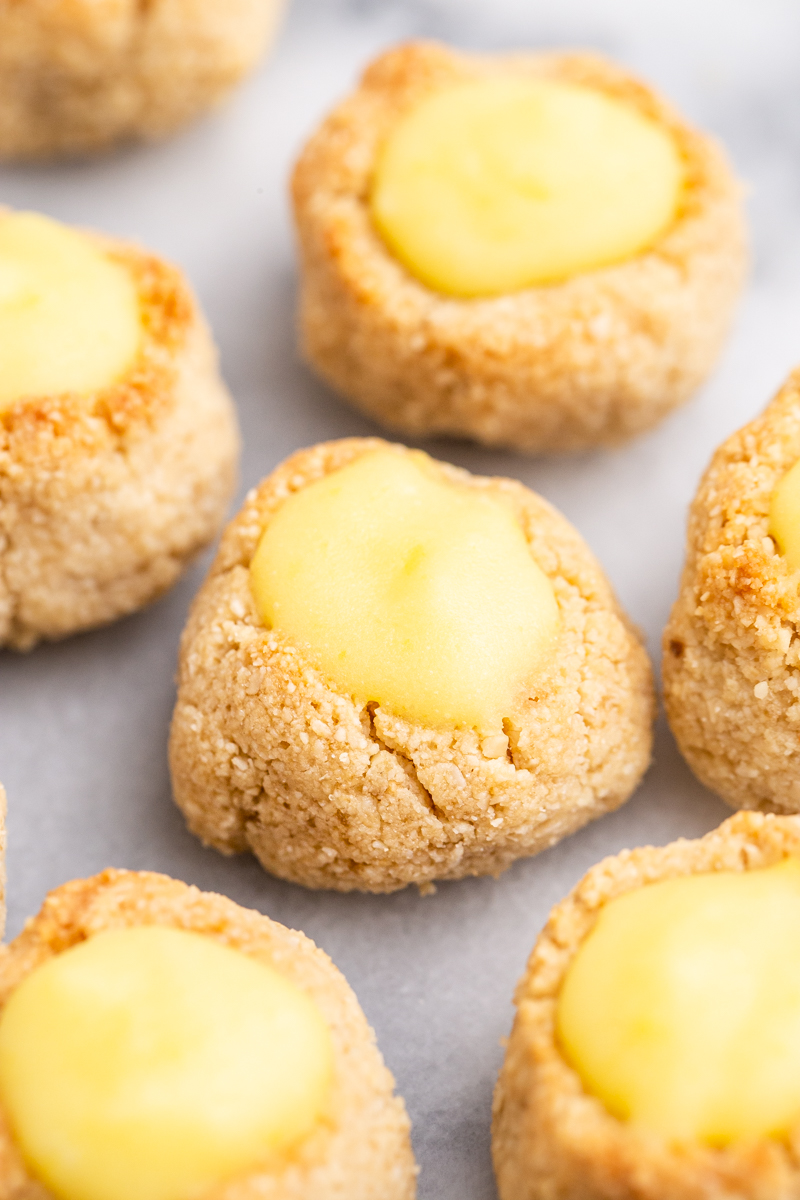 Close up of Keto Lemon Thumbprint Cookies on a marble cutting board.