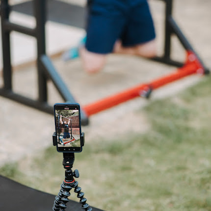 smartphone sur trepied filmant un homme qui fait du sport dans un parc