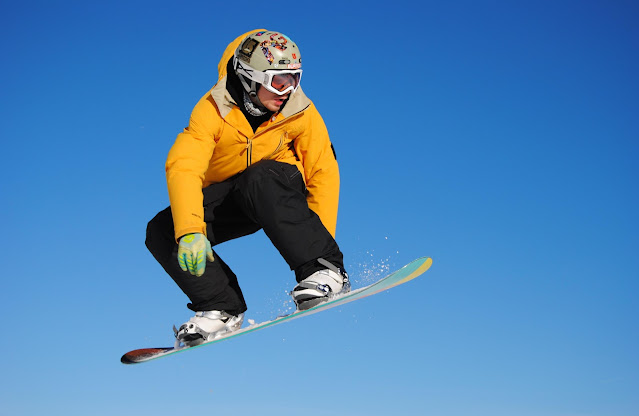 man on snowboard with blue sky background:Photo by Alessandro Maculotti on Unsplash