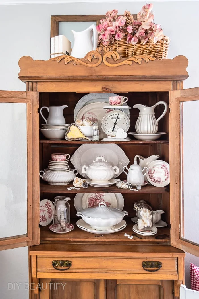 pine hutched with vintage ironstone and transferware dishes, glass jars and cloche