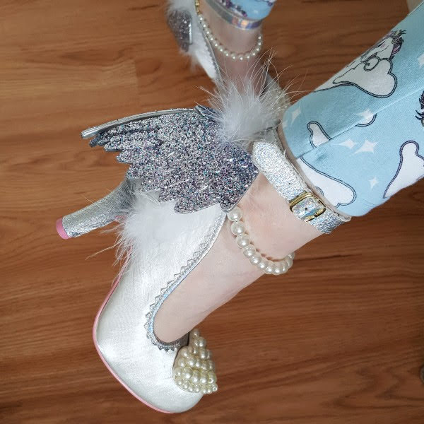 wearing white and silver glitter wing shoes with unicorn pyjamas