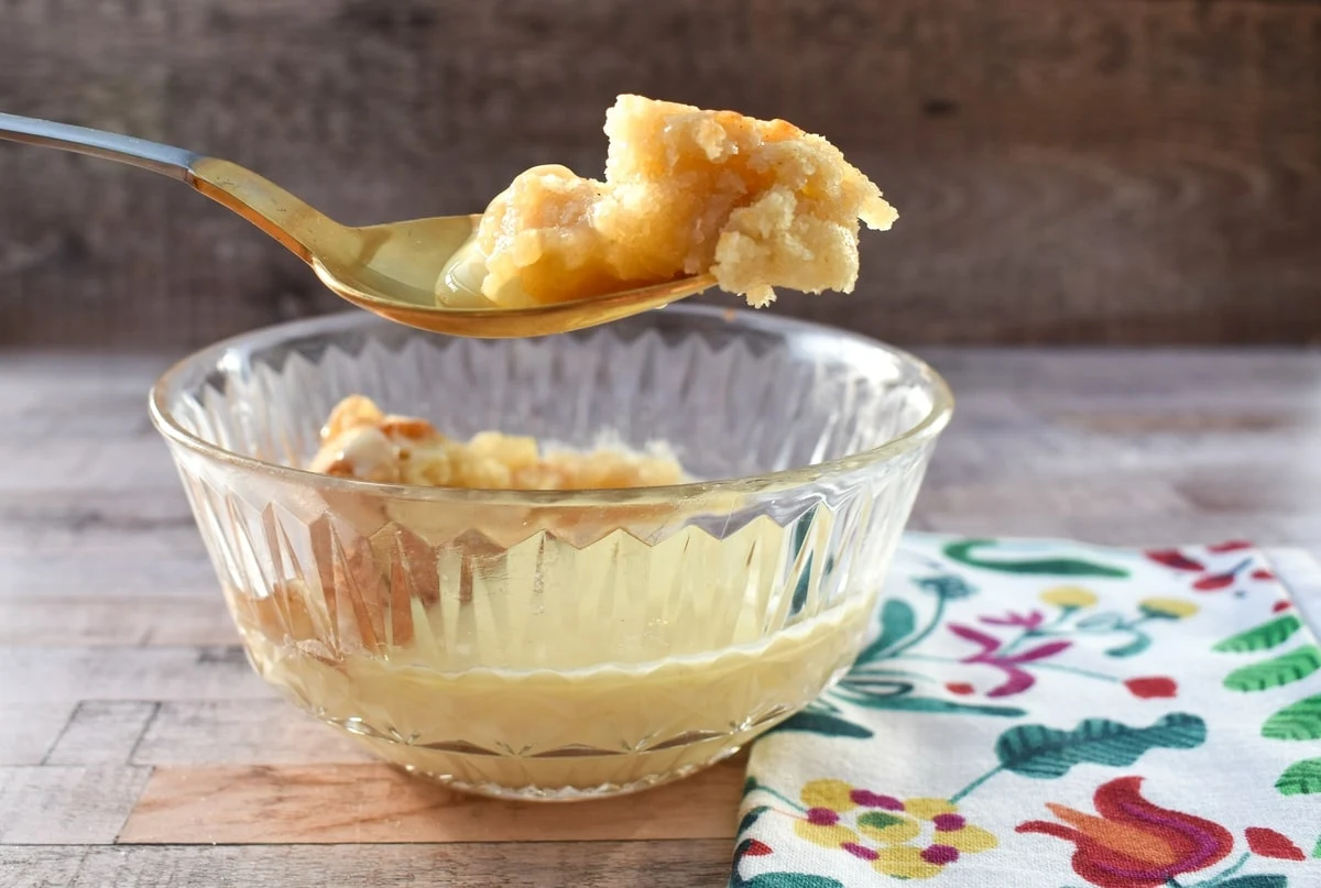 A spoonful of apple pudding with custard