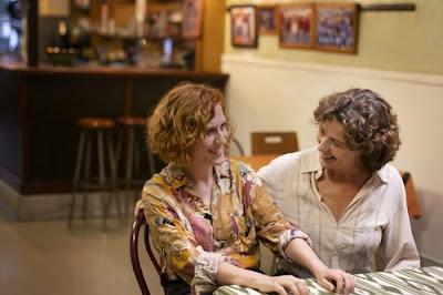 Dos mujeres en un bar se miran y sonríen