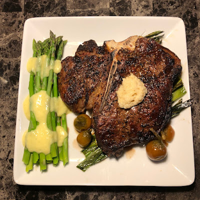 Rare grilled porterhouse with some steamed asparagus with hollandaise