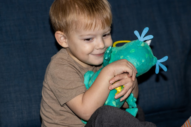 A young boy cuddling a plush animal toy