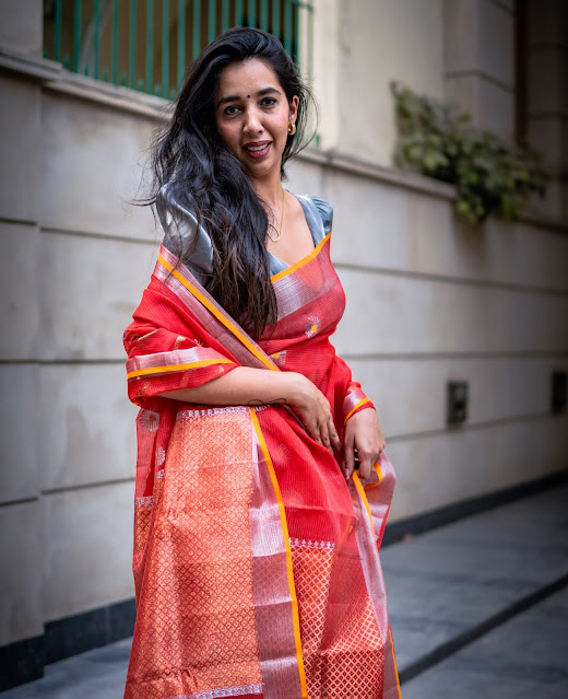 Tomato red Kota doria saree with floral vine border.