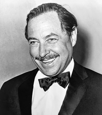 Black and white headshot of Tennessee Williams smiling big