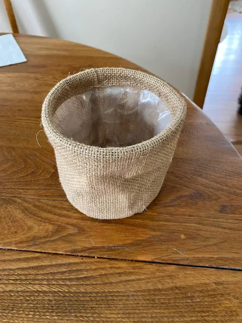 Photo of a small burlap, plastic lined planter.