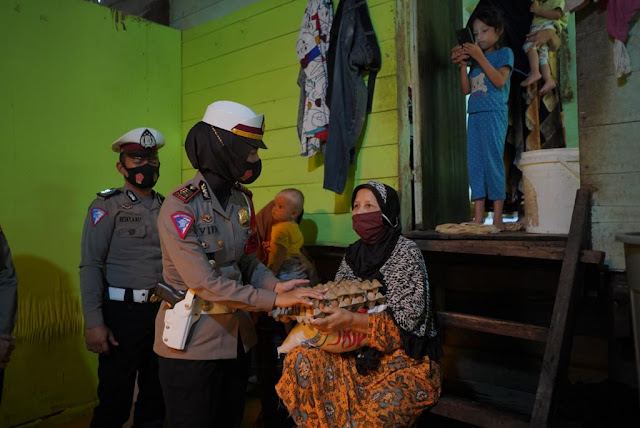 Kasatlantas Polres Lhokseumawe AKP Vifa Fibriana Sari menyerahkan bantuan sembako kepada masyarakat korban banjir di Aceh Utara