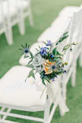 blue floral with greenery tied on the chairs