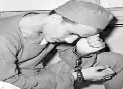 سفاح كرموز سعد اسكندر يرتدي ملابس السجن وقيود الكلبشات في يديه يجلس نادماً بعد القبض عليه والحكم بإعدامه