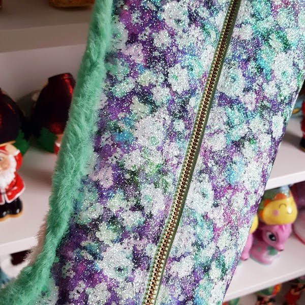 close up of purple floral glitter shaft on boot with green fur trim