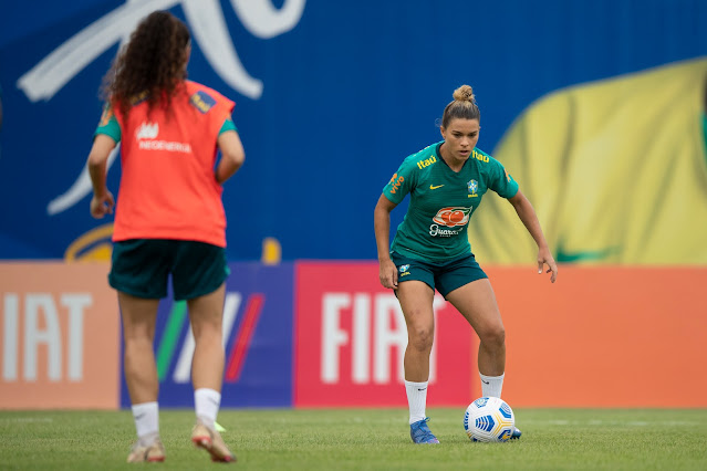 De verde, Tamires toca a bola durante treino da seleção