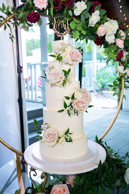 5 tier white cake with pink flowers and gold hoop stand