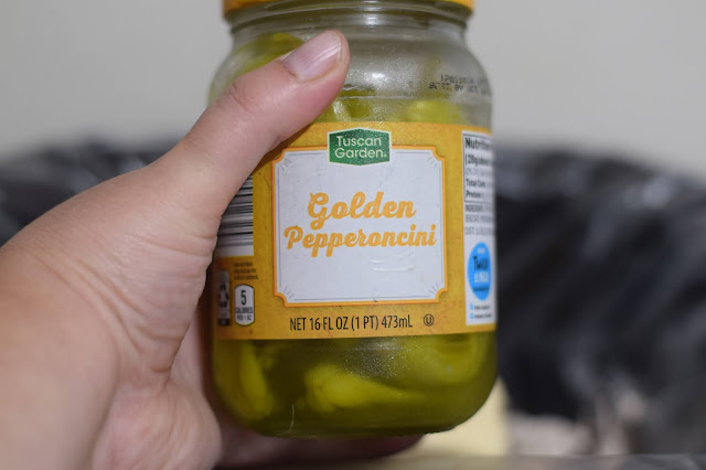 Pepperoncini being added to the crockpot.