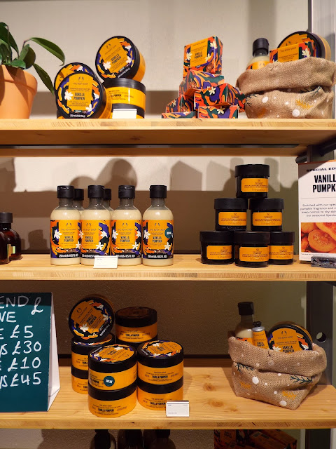 Three shelves of the Vanilla Pumpkin skincare range sit proudly in shades of orange, on wooden shelving.