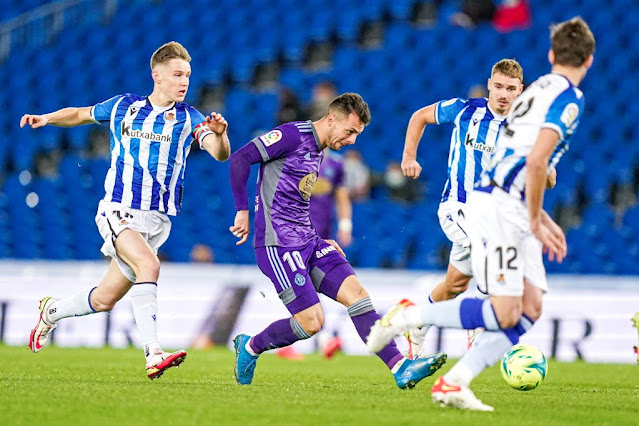 Óscar Plano dispara a puerta sin que Turrientes y Pacheco puedan impedirlo. REAL SOCIEDAD DE FÚTBOL B 0 REAL VALLADOLID C. F. 2 Domingo 19/12/2021: 18:15 horas. Campeonato de Liga de 2ª División, jornada 21. San Sebastián, Guipúzcoa, Reale Arena