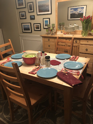 A picture of the table set for dinner with 5 place settings.