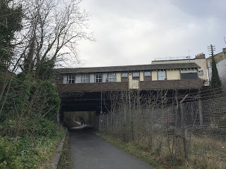 A photograph of Newhaven Station from Hawthornvale Path.  The path runs underneath the station on what was once the railway line, but is now for pedestrians and cyclists.  Photograph by Kevin Nosferatu for the Skulferatu Project