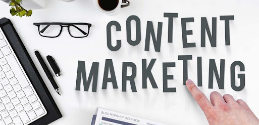 Content marketing symbols on a work table with computer keyboard, a pen and eye glasses.