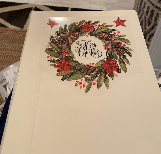 Photo of a Christmas decor transfer being applied to a hollow book cover.