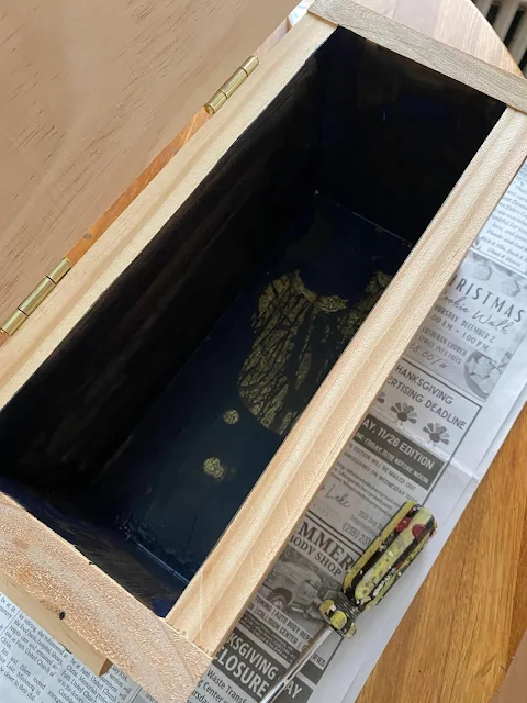Photo of the inside of a thrift store wooden box.