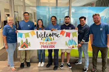 Parkside team standing with Camp Parkside sign
