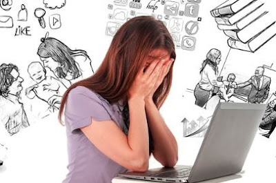 A woman with long hair, sitting at a laptop with her hands over her eyes, in apparent distress