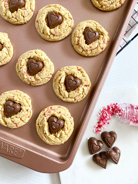 Rose gold cookie sheet filled with Valentine's Day cookies