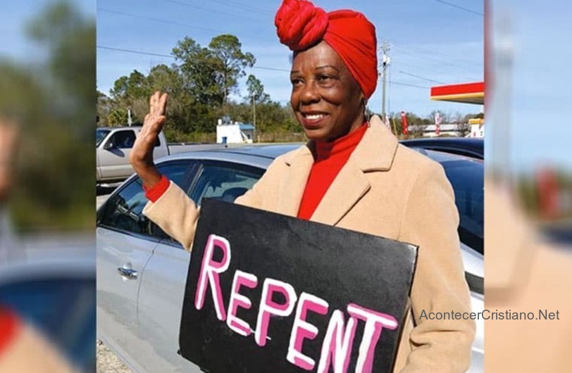 Mujer evangeliza con pancartas con temas de fe