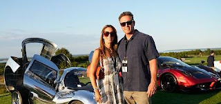 Bella's parents posing for picture while classic car in the background