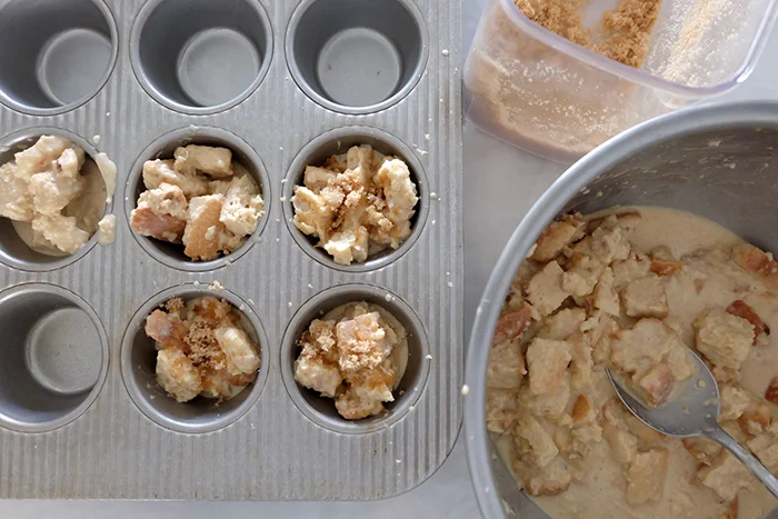 adding bread cubes and custard to muffin pan