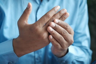 a man massaging his hands | chiropractic Ann Arbor