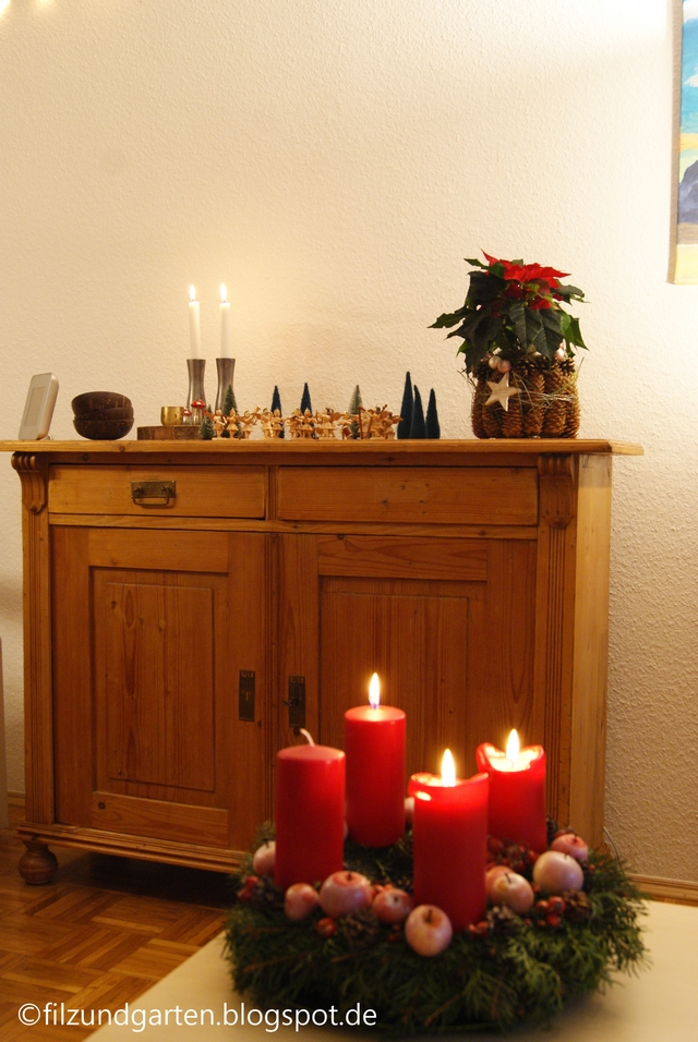 Adventskranz mit nachhaltigen Kerzen und kleinen Äpfeln dekoriert