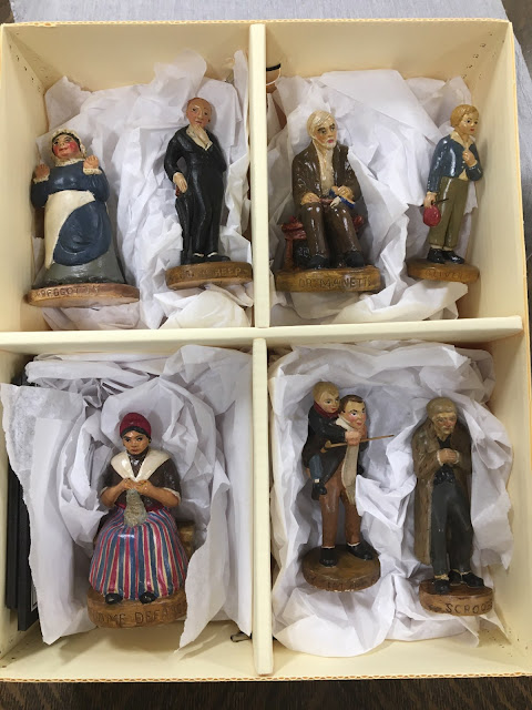 Photo of the 7 ceramic WPA Charles Dickens figurines in a box.