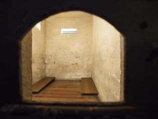 The inside of a cell with a bench on either side in the Justice and Police Museum