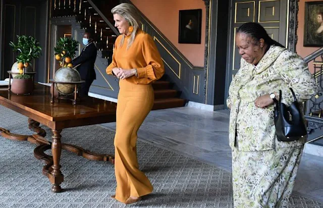 Queen Maxima wore a new orange silk blouse from Natan, and orange trousers by Natan. Fahoma green colour flower earrings