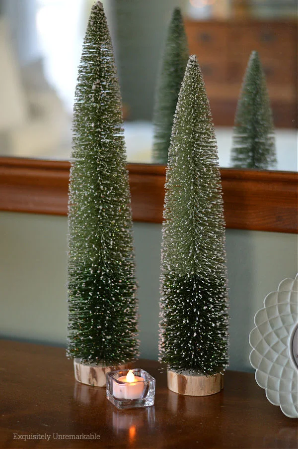 Bottle Brush Trees and a votive candle on a bedroom dresser