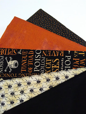 fabric:  orange, black with orange and cream Halloween text, cream with black spiders, black with tiny orange stars