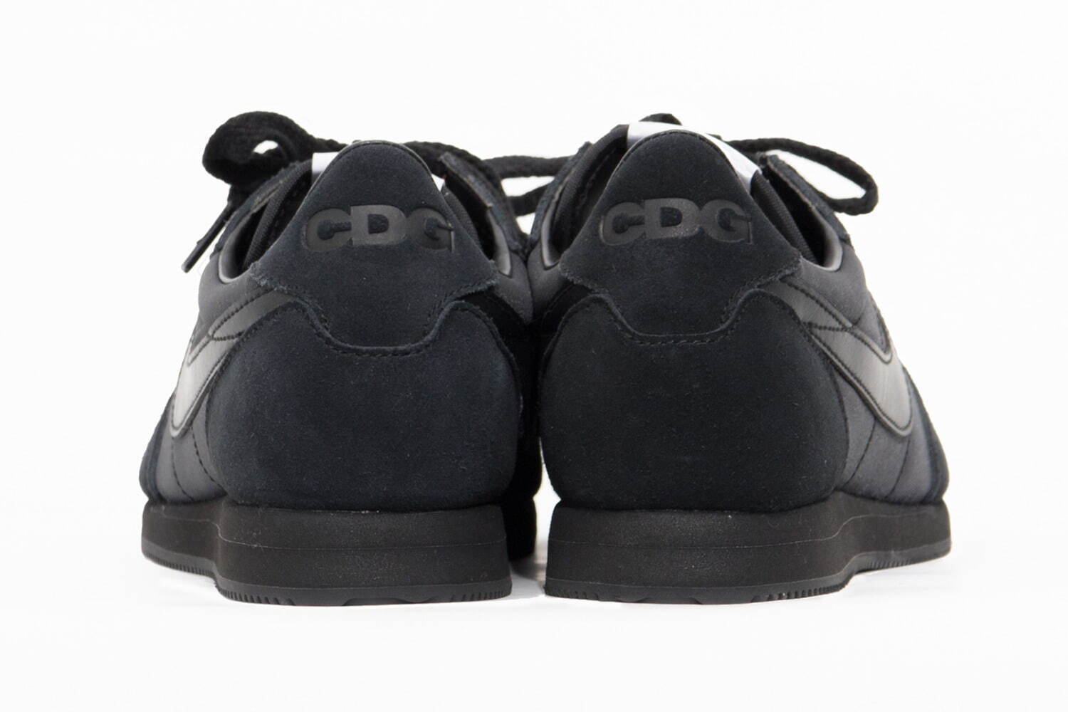 Image may contain Black Comme des Garcons Clothing Apparel Human Person Fashion Runway Nike and Sneakers