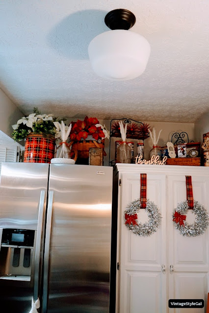 Christmas decorations in the kitchen on top of cabinet and fridge