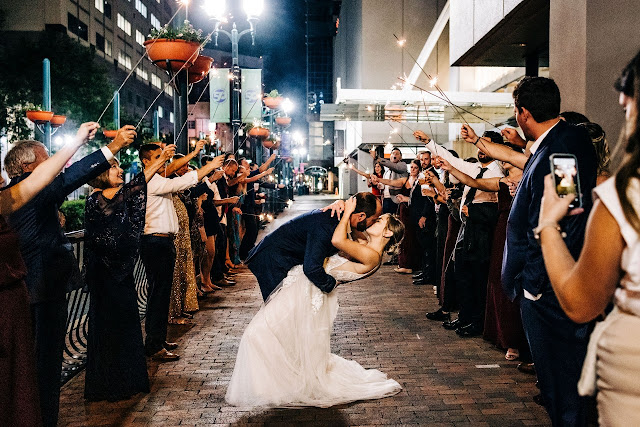 groom kissing bride and dipping her in sparklers