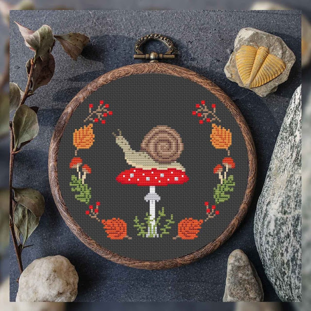 A beautiful little snail on a red capped mushroom surrounded by Autumn leaves embroidery