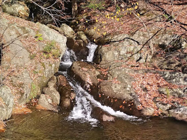 waterfall gushing between the rocks and pooling at the bottom