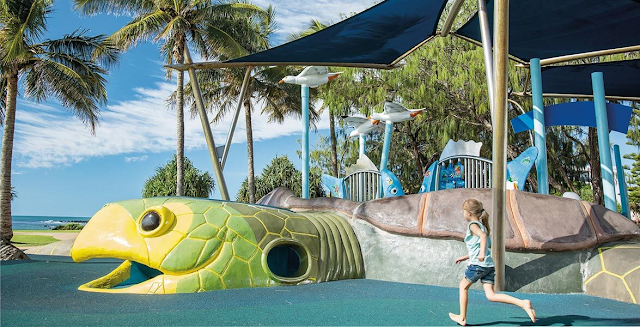 A turtle shaped playground with a little girl running