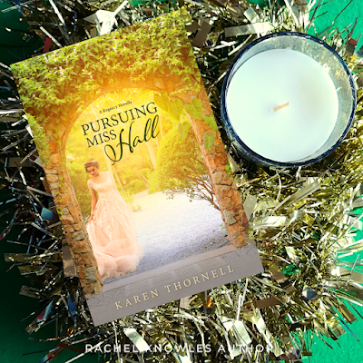 Tinsel and candle with front cover of Pursuing Miss Hall by Karen Thornell