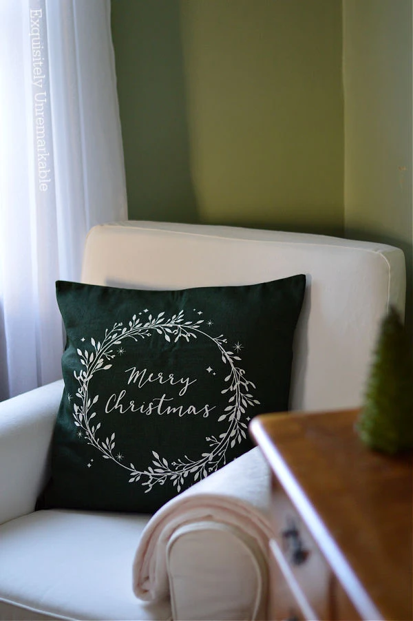 Green Merry Christmas Pillow on a white chair