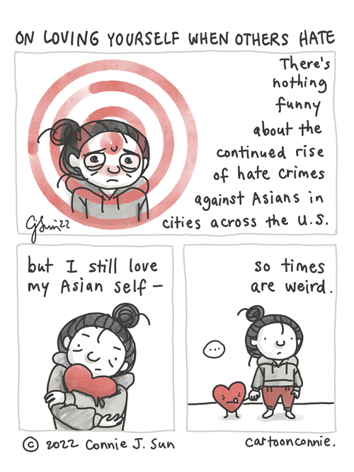 3-panel comic of an Asian American woman, learning to love herself in the face of hate. Monochrome palette except for red accents. Panel 1, a simple illustration of a girl with a bun and a large red target pointed on her. She looks anxious and scared. Text reads: "There's nothing funny about the continued rise of hate crimes against Asians in cities across the U.S." In panel 2, she is hugging a large red heart. In panel 3, she puts the heart down on its own feet and they hold hands. Text reads: "- but I still love my Asian self, so times are weird." Titled "On Loving Yourself When Others Hate." Original comic strip by Connie Sun, cartoonconnie, 2022.