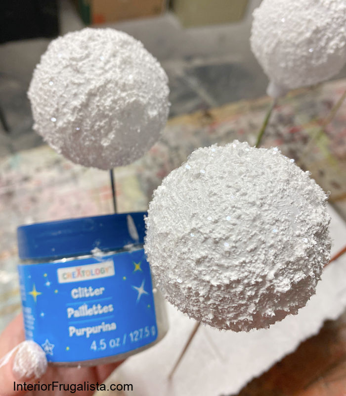 Make the faux snow covered recycled Christmas bauble ornaments glisten with fine clear glitter.